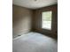 Clean, unfinished bedroom with a freshly painted wall and a single window, ready for flooring and personalization at 21712 Sw Rainbow Lakes Blvd, Dunnellon, FL 34431