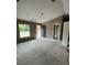Bright, unfinished living room with fresh paint, featuring a large window and an entryway to other parts of the house at 21712 Sw Rainbow Lakes Blvd, Dunnellon, FL 34431