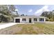Charming single-story home featuring a modern exterior, a dark one-car garage, and a well-manicured front lawn at 23995 Nw Falcon Ave, Dunnellon, FL 34431