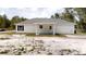 Rear exterior of a single-story home with neutral siding and a covered back patio area with white columns at 23995 Nw Falcon Ave, Dunnellon, FL 34431