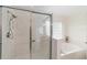 The bright bathroom features a glass-enclosed shower, separate tub, and tile walls at 2413 Se 23Rd St, Ocala, FL 34471