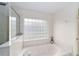 Bathroom featuring a luxurious soaking tub with jacuzzi jets and a frosted glass block window at 2413 Se 23Rd St, Ocala, FL 34471