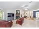 Inviting living room featuring a stone fireplace, ceiling fan, and neutral carpet at 2413 Se 23Rd St, Ocala, FL 34471
