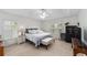 The main bedroom has a large bed, ceiling fan, shutters, and a dark-colored safe in the corner at 2413 Se 23Rd St, Ocala, FL 34471