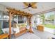 The screened porch features a wooden swing, leafy ceiling fan, and relaxing outdoor space at 2413 Se 23Rd St, Ocala, FL 34471
