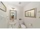 Powder room features a pedestal sink and toilet with decorative mirrors and modern fixtures at 2413 Se 23Rd St, Ocala, FL 34471