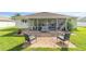 A brick-paved patio with outdoor furniture overlooks a well-maintained, grassy backyard at 2552 Ne 42Nd Rd, Ocala, FL 34470