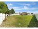 Expansive, well-maintained backyard with a white fence, lush greenery, and a charming shed at 2552 Ne 42Nd Rd, Ocala, FL 34470