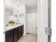 Well-lit bathroom with double sinks, dark cabinetry, and a decorative floral shower curtain at 2552 Ne 42Nd Rd, Ocala, FL 34470