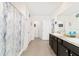 Bright bathroom featuring double vanity, dark cabinets, and a blue patterned shower curtain at 2552 Ne 42Nd Rd, Ocala, FL 34470