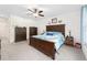 Spacious main bedroom featuring carpeted floors, ceiling fan, and a king bed with a decorative blue comforter at 2552 Ne 42Nd Rd, Ocala, FL 34470
