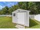 An outdoor shed with a weather vane sits in the backyard of this landscaped property with a white fence line at 2552 Ne 42Nd Rd, Ocala, FL 34470