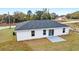 Rear view of a home with a gray roof, white siding, and a concrete patio at 2871 Sw 147Th Ter, Ocala, FL 34481