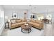 Staged living room featuring neutral walls and flooring, contemporary furniture, and open access to the kitchen at 2871 Sw 147Th Ter, Ocala, FL 34481
