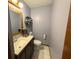 Compact half bathroom with granite countertop, modern sink and toilet, and a decorative mirror at 3545 Se 24Th Ave, Ocala, FL 34471