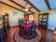 A dining room with wood floors, wood beams, a ceiling fan, and a round rug under the table at 3545 Se 24Th Ave, Ocala, FL 34471