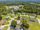 Property aerial view near a school, featuring a private pool and green, fenced yard at 4300 Nw 4Th Cir, Ocala, FL 34475
