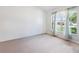 Bright, carpeted bedroom with a large window and sheer curtains, offering a comfortable living space at 4300 Nw 4Th Cir, Ocala, FL 34475