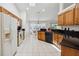 Bright kitchen featuring tile flooring, wooden cabinets, and black countertops with modern appliances at 4300 Nw 4Th Cir, Ocala, FL 34475