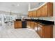 Bright kitchen featuring tile flooring, wooden cabinets, and black countertops overlooking the dining area at 4300 Nw 4Th Cir, Ocala, FL 34475