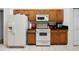 Cozy kitchen featuring wood cabinets and white appliances with a microwave at 4300 Nw 4Th Cir, Ocala, FL 34475