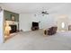 Bright living room featuring a fireplace, neutral carpet, and a ceiling fan at 4300 Nw 4Th Cir, Ocala, FL 34475