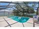 Screened-in pool area with clear blue water, lounge chair, and a view of the backyard at 4300 Nw 4Th Cir, Ocala, FL 34475