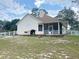 Exterior of the home with white siding, a patio, grill, and white fencing, perfect for outdoor living at 5917 Ne 61St Avenue Rd, Silver Springs, FL 34488