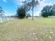 Picturesque backyard with a white fence and mature trees, creating a serene and private outdoor space at 5917 Ne 61St Avenue Rd, Silver Springs, FL 34488