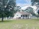 Back exterior view with a patio, grill, and white fencing, perfect for outdoor entertaining and relaxation at 5917 Ne 61St Avenue Rd, Silver Springs, FL 34488