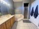 Comfortable bathroom with double sinks, large mirror, tiled floors, and a relaxing tub and shower stall at 5917 Ne 61St Avenue Rd, Silver Springs, FL 34488
