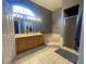 Beautiful bathroom with double sinks, large mirror, tiled floors, and a tub to enjoy after a long day at 5917 Ne 61St Avenue Rd, Silver Springs, FL 34488