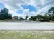 Community entrance with lush greenery, mature trees, and a well-maintained roadway at 5917 Ne 61St Avenue Rd, Silver Springs, FL 34488