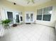 Covered patio featuring neutral tile, fan, and double doors, providing a relaxing outdoor space at 5917 Ne 61St Avenue Rd, Silver Springs, FL 34488