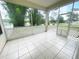 Screened-in porch with white lattice and neutral tile, offering a comfortable outdoor retreat at 5917 Ne 61St Avenue Rd, Silver Springs, FL 34488