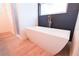 Modern bathroom featuring a freestanding tub, black accent wall, and a tiled walk-in shower at 7 Hill Prince Dr, Ocala, FL 34482