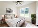 Bedroom with light-colored walls, light wood-look floors, large window, bed, and a potted plant at 7 Hill Prince Dr, Ocala, FL 34482