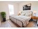 Bedroom with light-colored walls, light wood-look floors, large window, bed, and two side tables at 7 Hill Prince Dr, Ocala, FL 34482