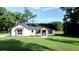 Charming single-story home with stone accents, gray roof and lush green lawn and manicured landscaping at 7 Hill Prince Dr, Ocala, FL 34482