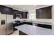 Modern kitchen features stainless steel appliances, granite countertops, and dark wood cabinetry at 7 Hill Prince Dr, Ocala, FL 34482