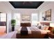 A main bedroom with a dark ceiling, two windows, light colored floors, and a private bathroom at 7 Hill Prince Dr, Ocala, FL 34482