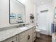 Bathroom featuring a white vanity with speckled countertop, a large mirror, and a bathtub with white subway tiles at 7695 Sw 188Th Ave, Dunnellon, FL 34432