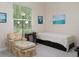 Bedroom showcasing a plush chair, nautical artwork, natural light, and a neatly made single bed at 7695 Sw 188Th Ave, Dunnellon, FL 34432