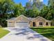 Charming single-story home with a well-manicured lawn, a driveway, and a three-car garage at 7695 Sw 188Th Ave, Dunnellon, FL 34432
