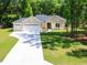 Inviting single-story home featuring a spacious driveway, three-car garage, and a beautifully landscaped front yard at 7695 Sw 188Th Ave, Dunnellon, FL 34432