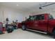 Spacious garage featuring epoxy floors, a large red truck, and ample workspace at 7695 Sw 188Th Ave, Dunnellon, FL 34432