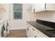 Laundry room with modern appliances, white cabinetry, dark countertops, and wood-look flooring at 7695 Sw 188Th Ave, Dunnellon, FL 34432