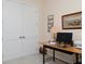 Home office featuring a wooden desk, decorations, and a pair of white doors with silver hardware at 7695 Sw 188Th Ave, Dunnellon, FL 34432
