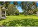 Backyard featuring lush green grass and mature trees offering a serene outdoor space at 8 Diamond Club Rd, Ocala, FL 34472