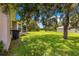 Spacious backyard with manicured lawn, mature trees, and a view of the adjacent property at 8 Diamond Club Rd, Ocala, FL 34472